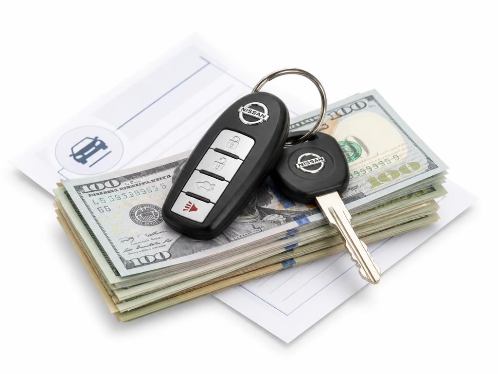 Nissan key fob on a stack of cash and a trade-in appraisal form
